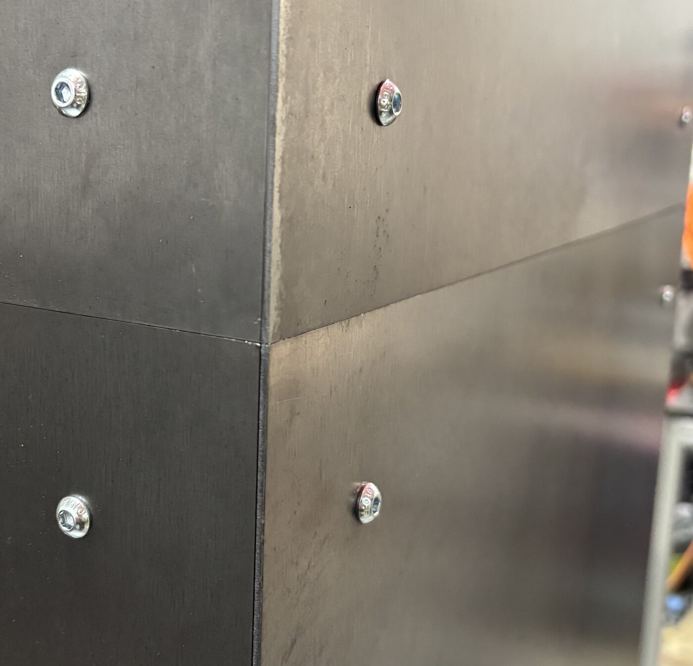 Close-up of welded steel panels joined with countersunk bolts — a fabrication detail
